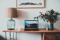 An elegant office table lamp placed on a wooden desk.