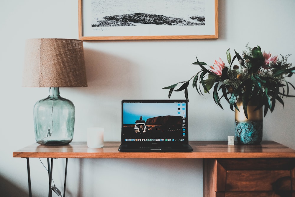 black laptop computer on brown wooden table