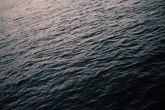 A serene scene of gentle sound waves rippling over a calm lake at sunset, symbolizing peaceful healing vibrations.