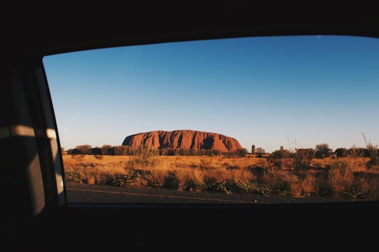 brown rock formation under blue sky during daytime in Uluru Australia
