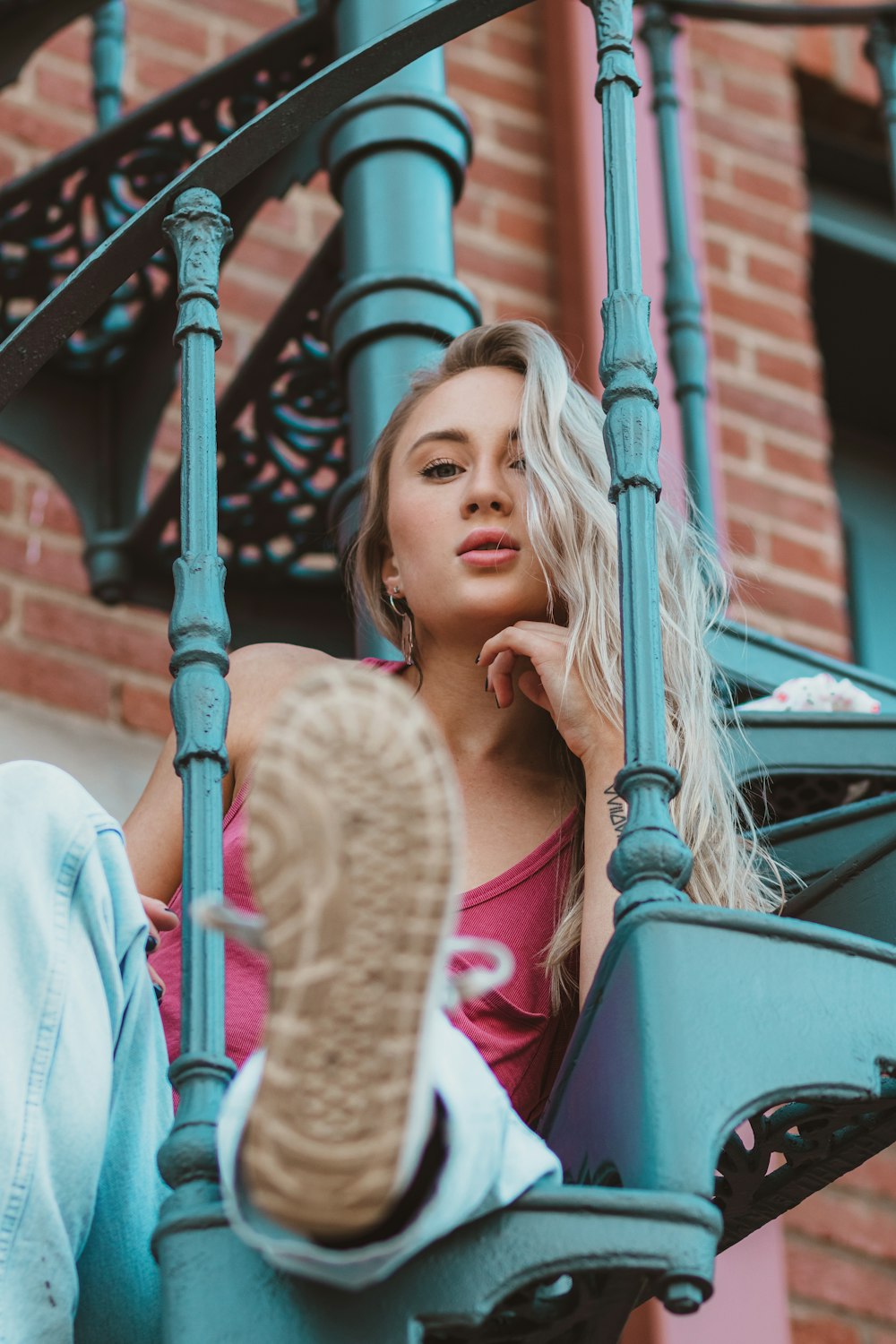 woman in beige long sleeve shirt leaning on black metal railings