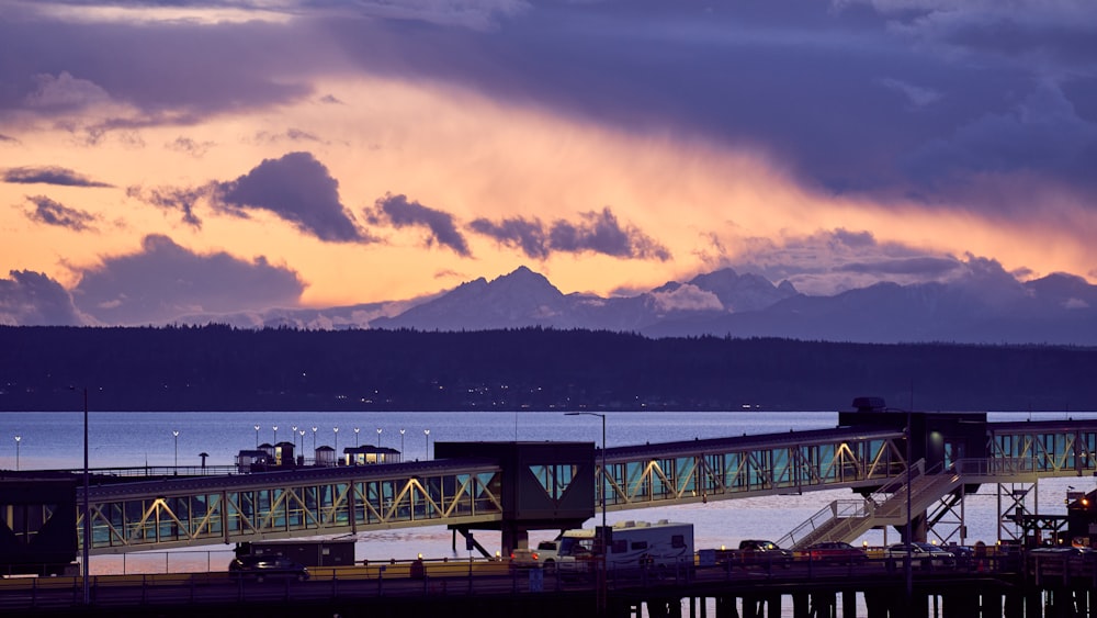 white and brown wooden dock near mountain during sunset