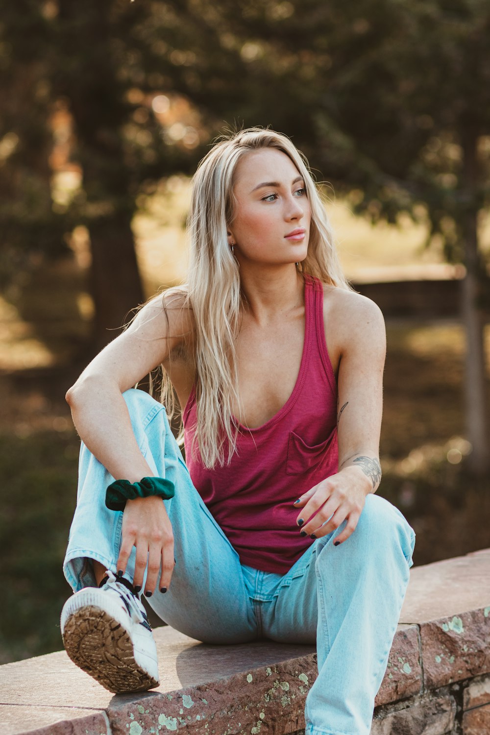 woman in red tank top sitting on brown wooden bench