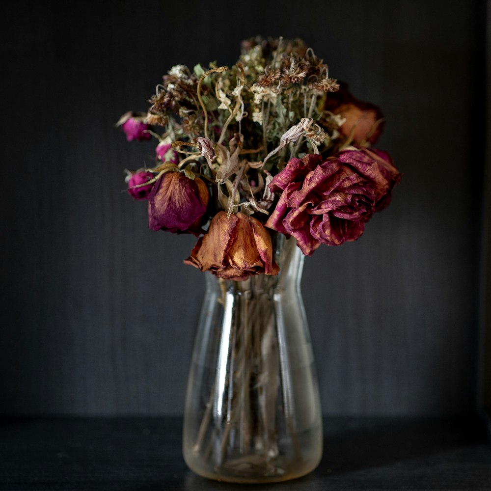 rosa und weiße Blumen in klarer Glasvase