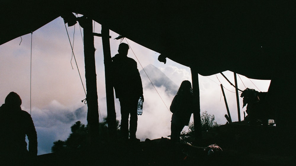 silhouette of 2 person standing on the ground during daytime