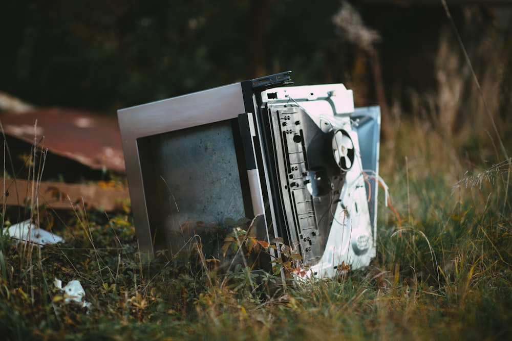 white and black vintage tv on green grass during daytime