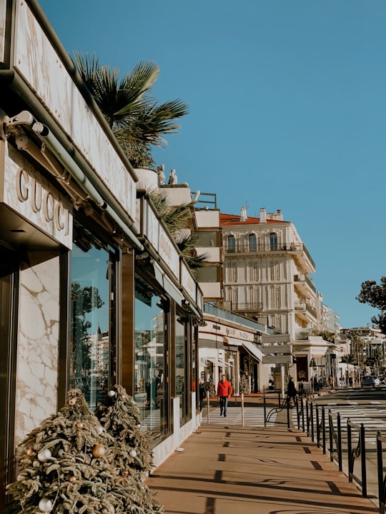 people walking on sidewalk near building during daytime in Cannes France