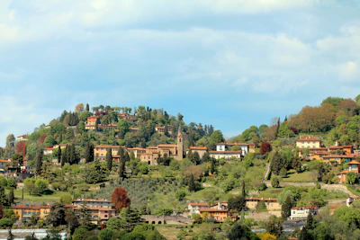 A cozy hillside villa surrounded by lush greenery under a clear blue sky.