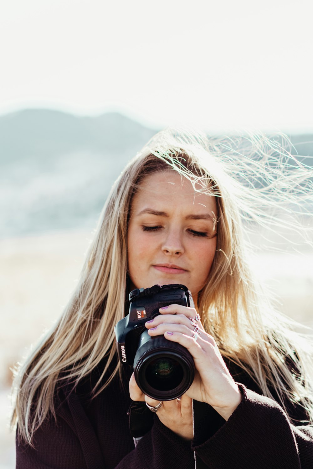 woman holding black dslr camera