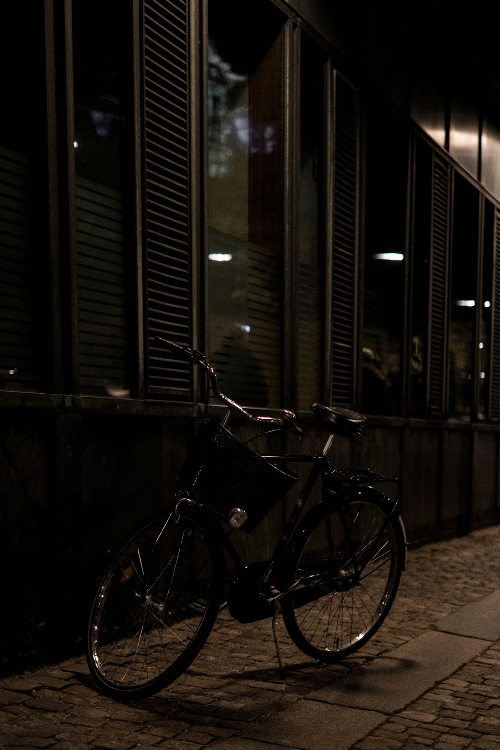 black city bike parked beside black metal fence