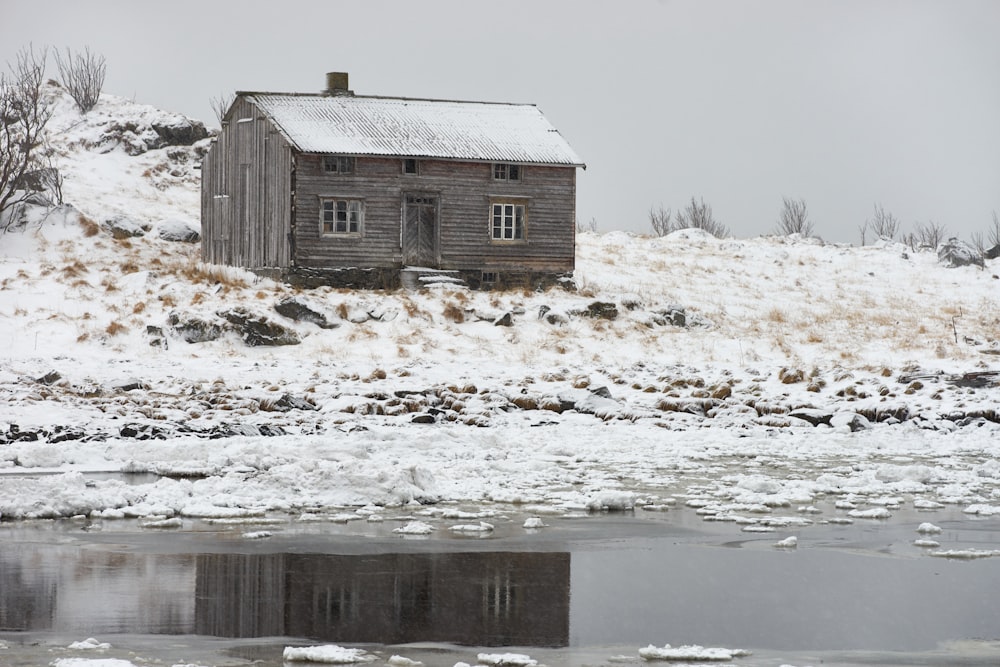 brown wooden house on snow covered ground during daytime