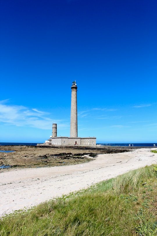 white and brown lighthouse near blue sea under blue sky during daytime in Gatteville Lighthouse France