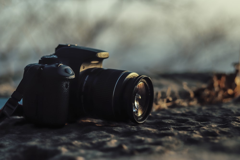 black nikon dslr camera on brown sand