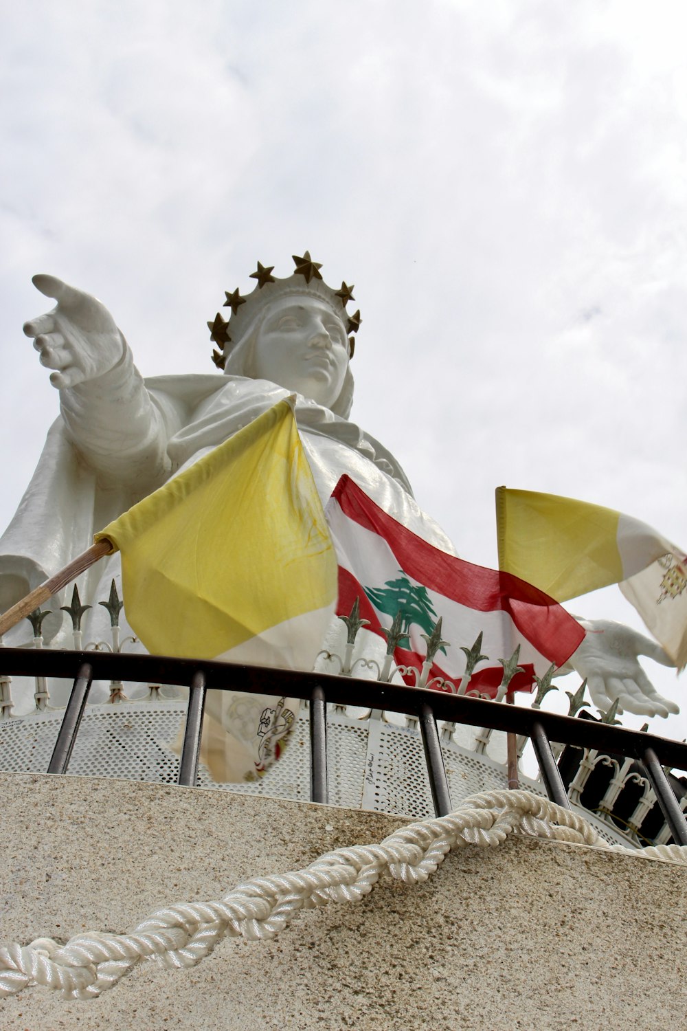 Statua in cemento bianco dell'uomo che tiene la bandiera dell'America