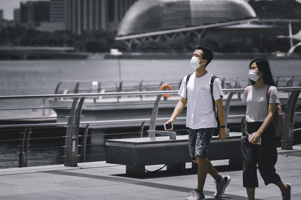 Homme en t-shirt blanc et short noir debout sur un banc noir pendant la journée