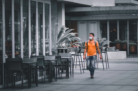 man in orange jacket sitting on black chair in Marina Bay Singapore