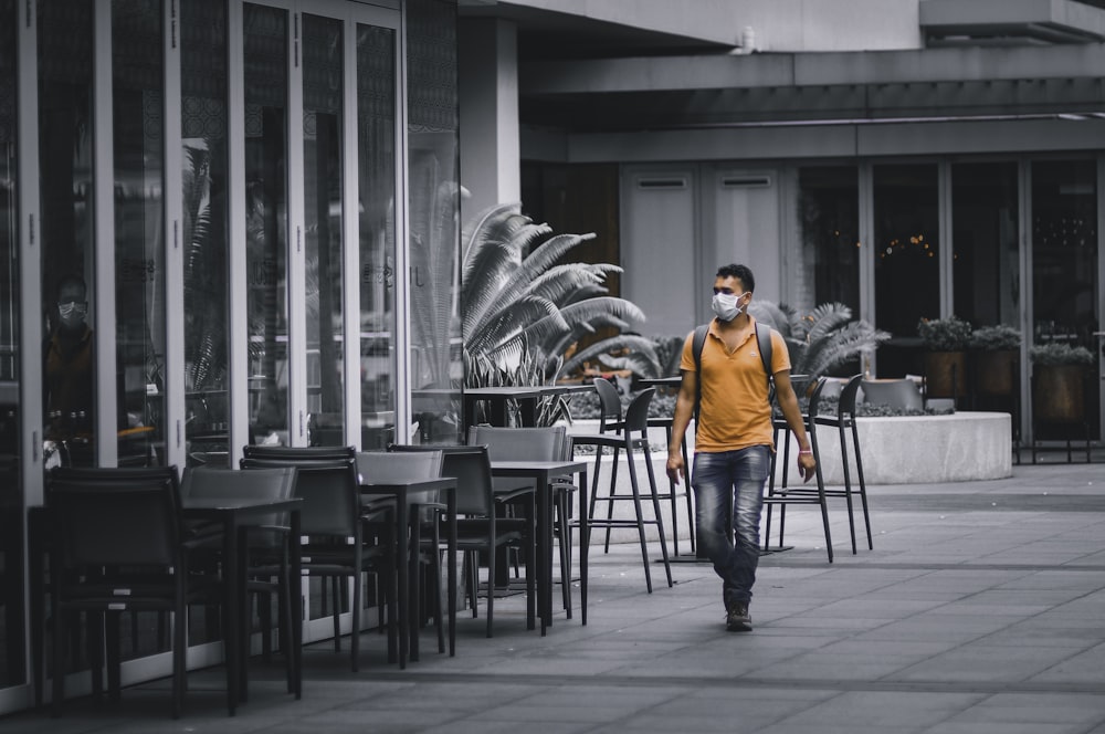 man in orange jacket sitting on black chair