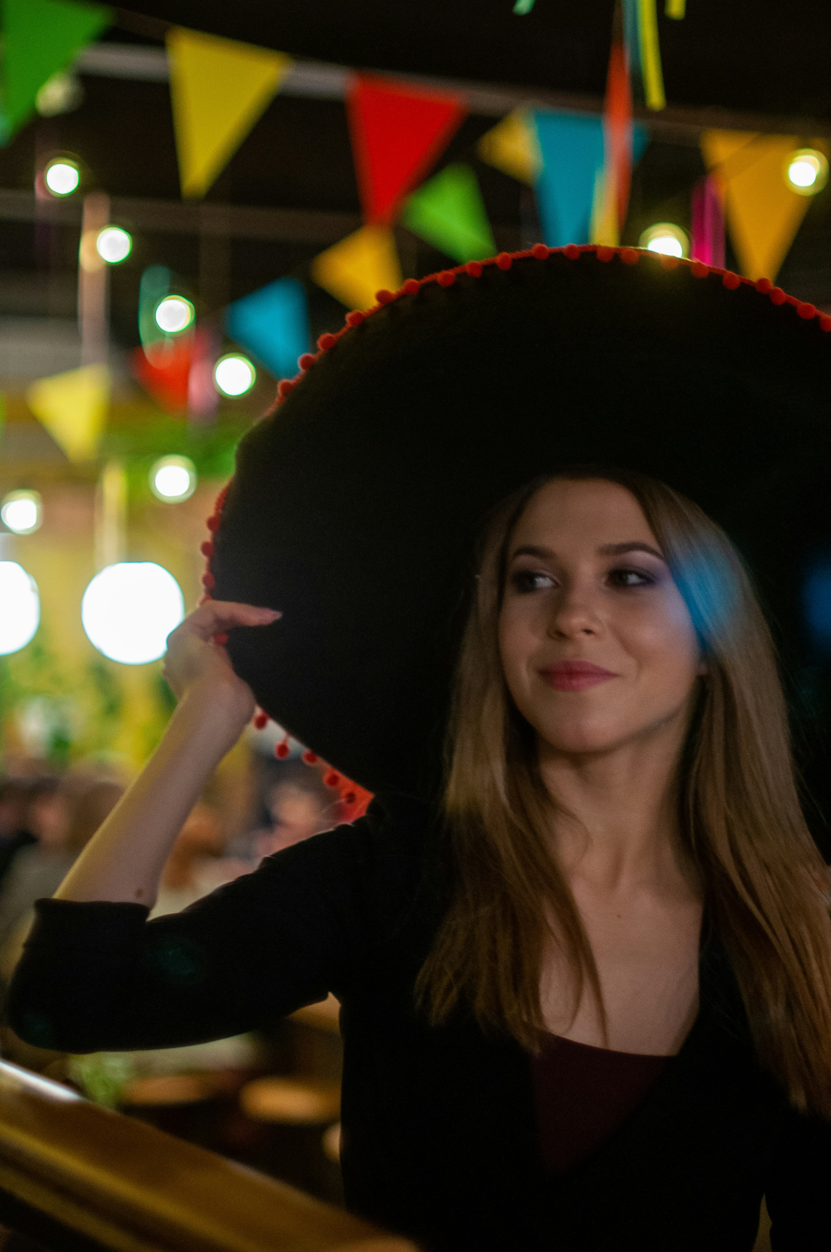 woman in black long sleeve shirt holding red and black hat