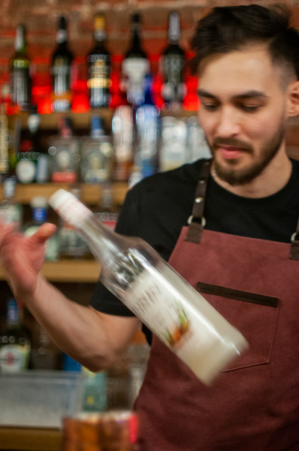 man in black crew neck t-shirt holding white labeled bottle