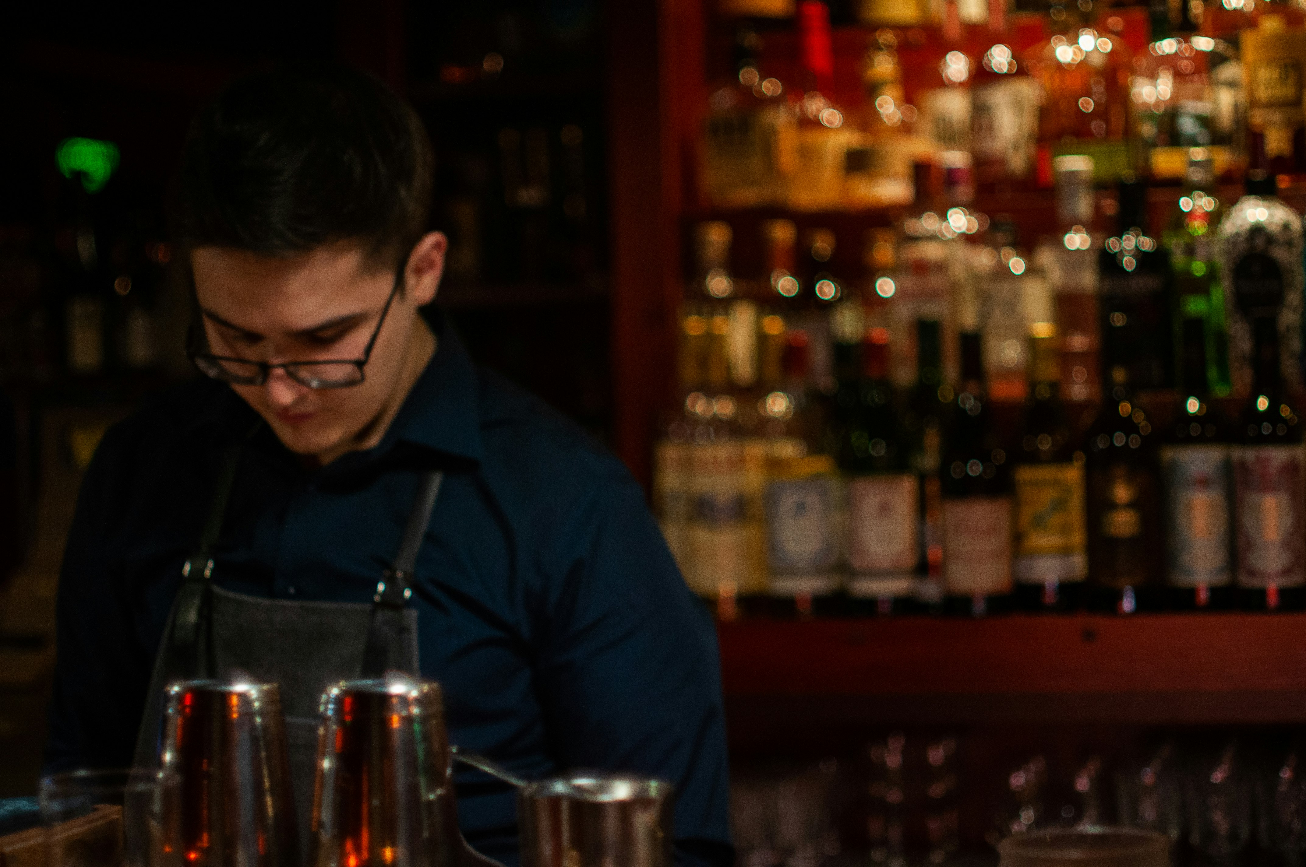 man in blue long sleeve shirt holding clear drinking glass