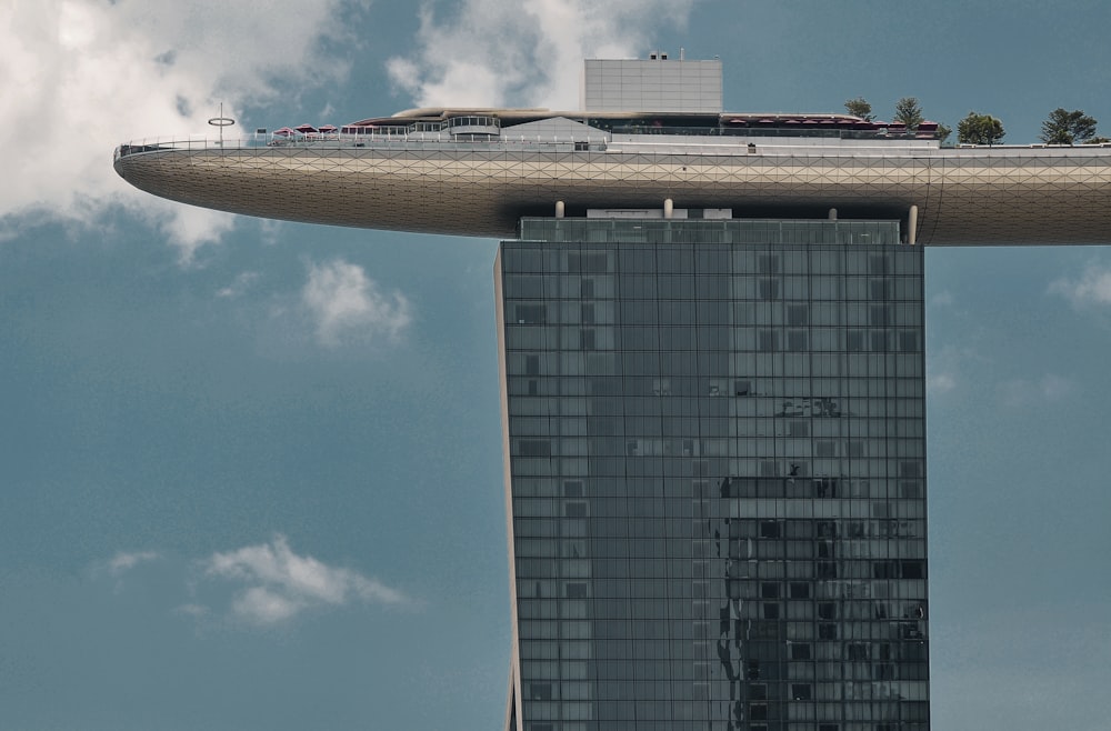 Edificio de gran altura con paredes de vidrio azul y blanco bajo el cielo azul durante el día