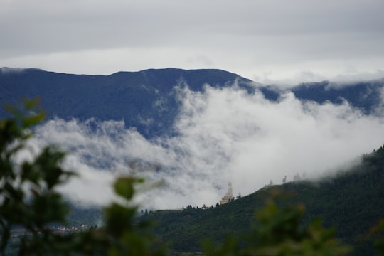 green mountain under white clouds during daytime in Thimphu Bhutan