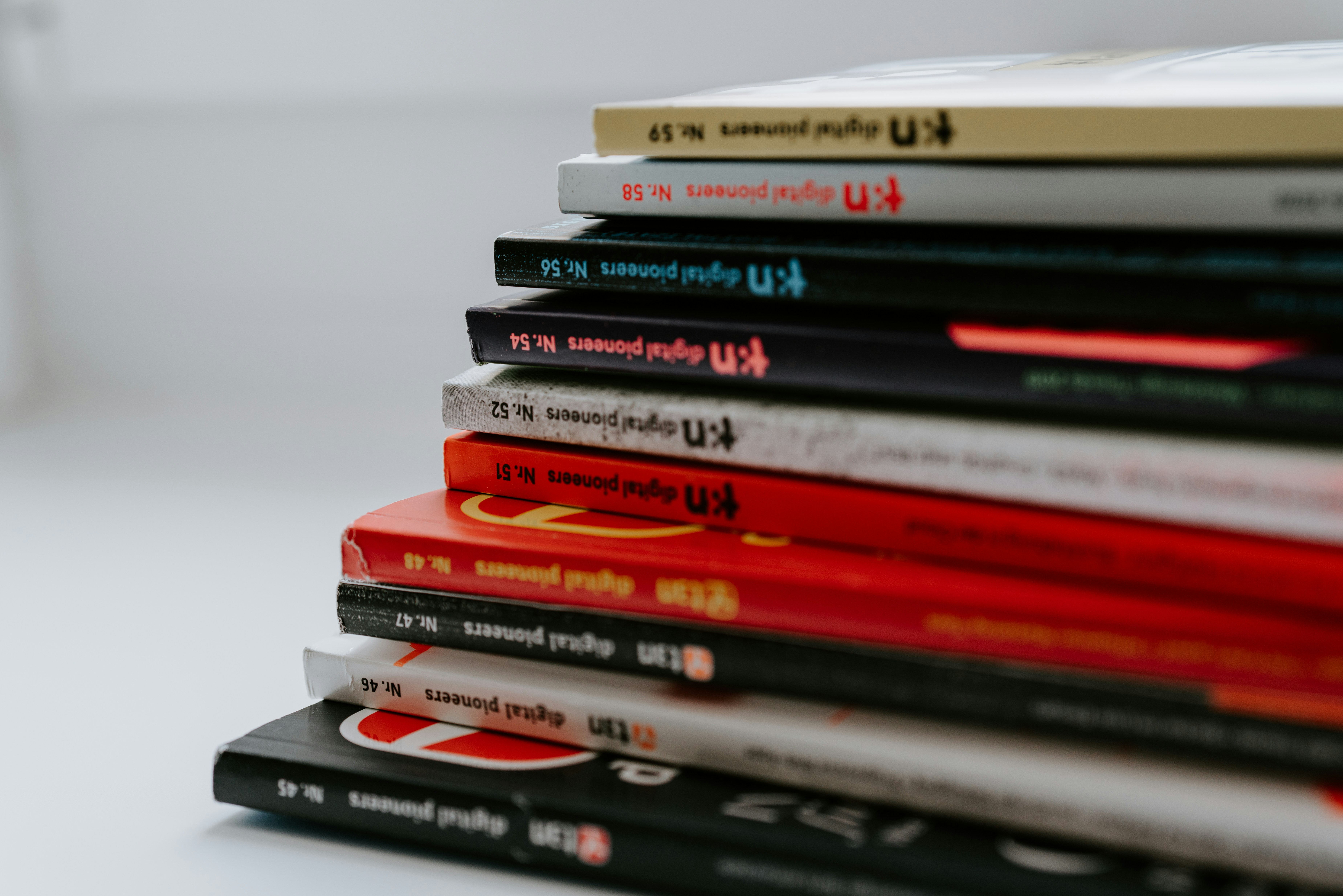 stack of assorted books on white table