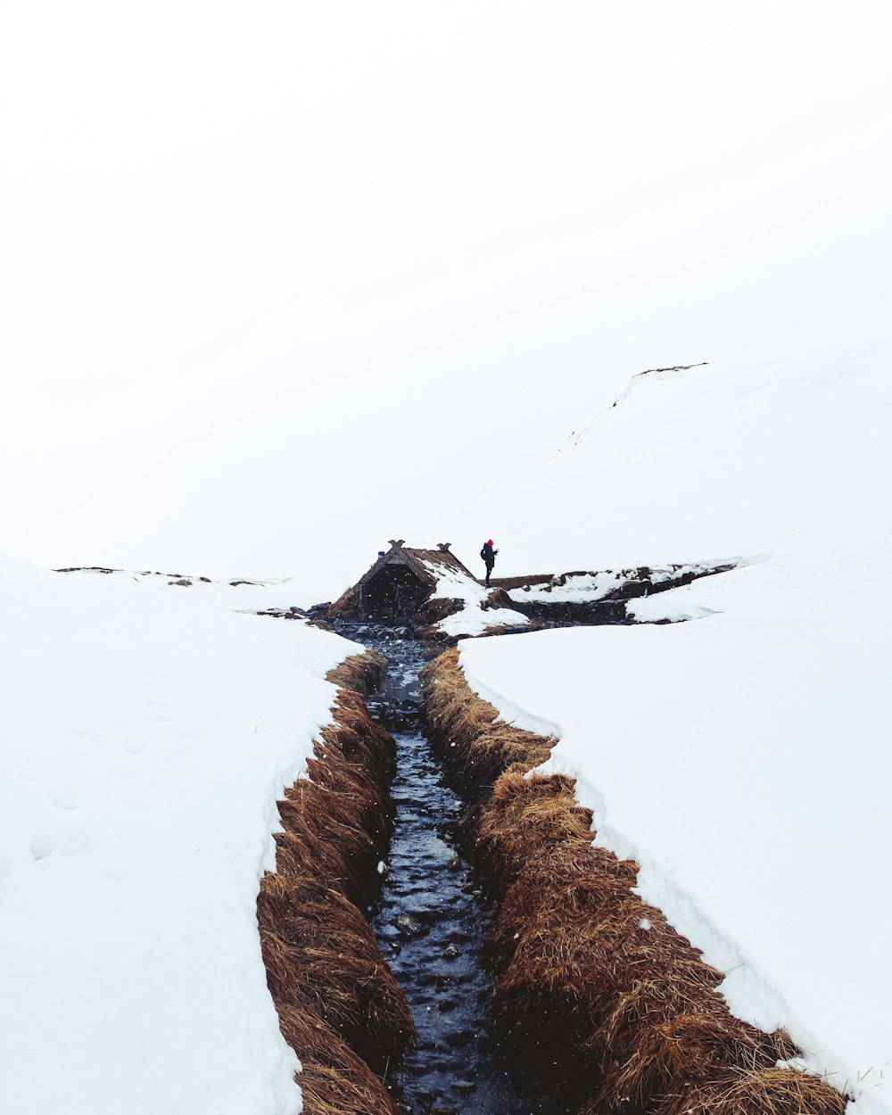 person in black jacket and black pants standing on snow covered ground during daytime