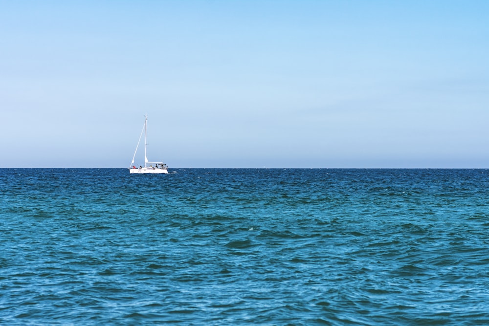 white boat on sea under gray sky