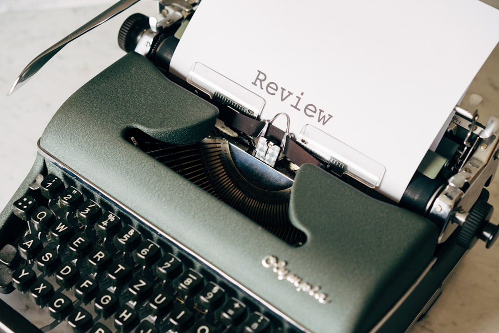máquina de escribir en blanco y negro sobre mesa blanca