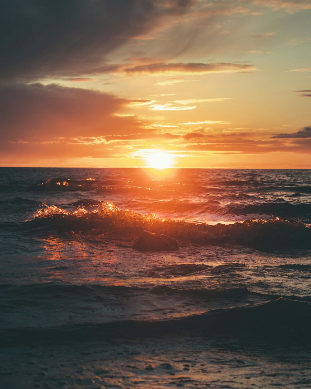 Olas del mar rompiendo en la costa durante la puesta de sol