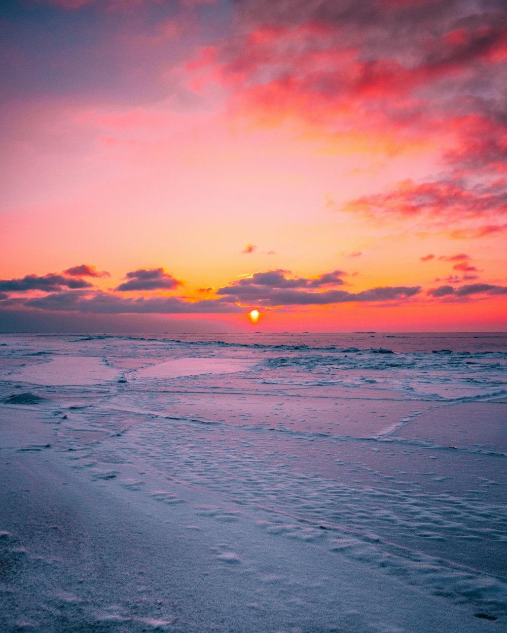 Meereswellen stürzen während des Sonnenuntergangs an Land