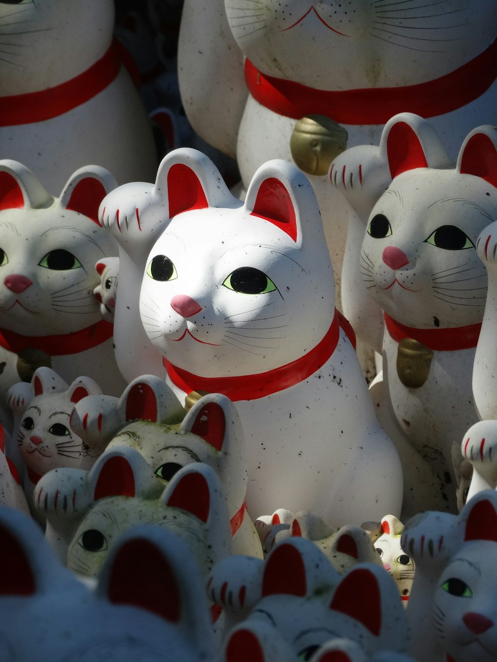 Figurine di gatti in ceramica bianca, rossa e gialla