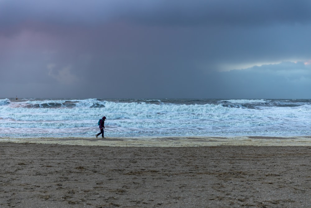 person walking on beach during daytime