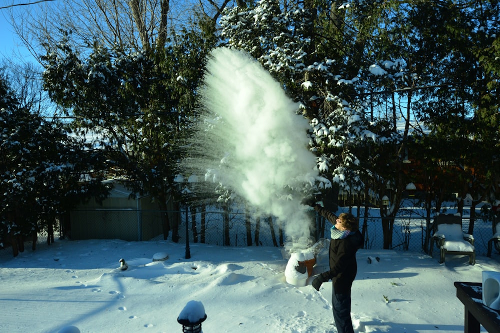 man in black jacket and black pants standing on snow covered ground during daytime