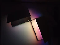 Person browsing ebooks on a sleek laptop with blue and purple ambient lighting.