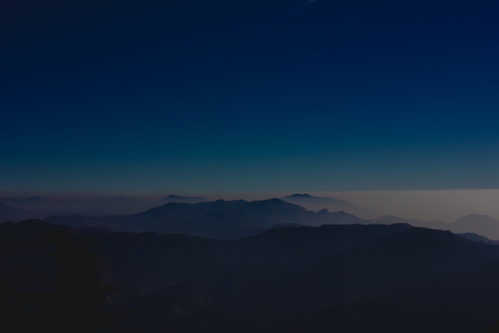 silhouette of mountains under blue sky during daytime