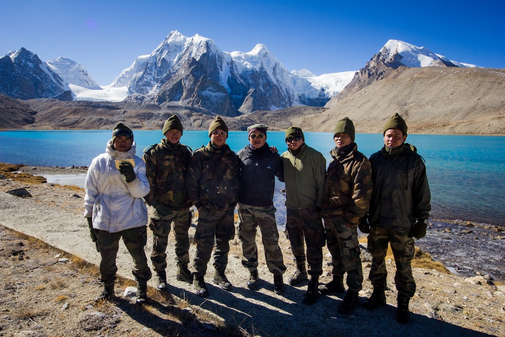 grupo de hombres de pie en la montaña rocosa durante el día