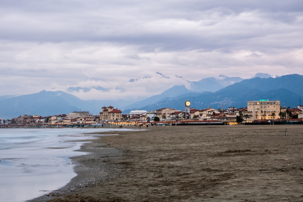 edifici della città vicino allo specchio d'acqua sotto nuvole bianche durante il giorno