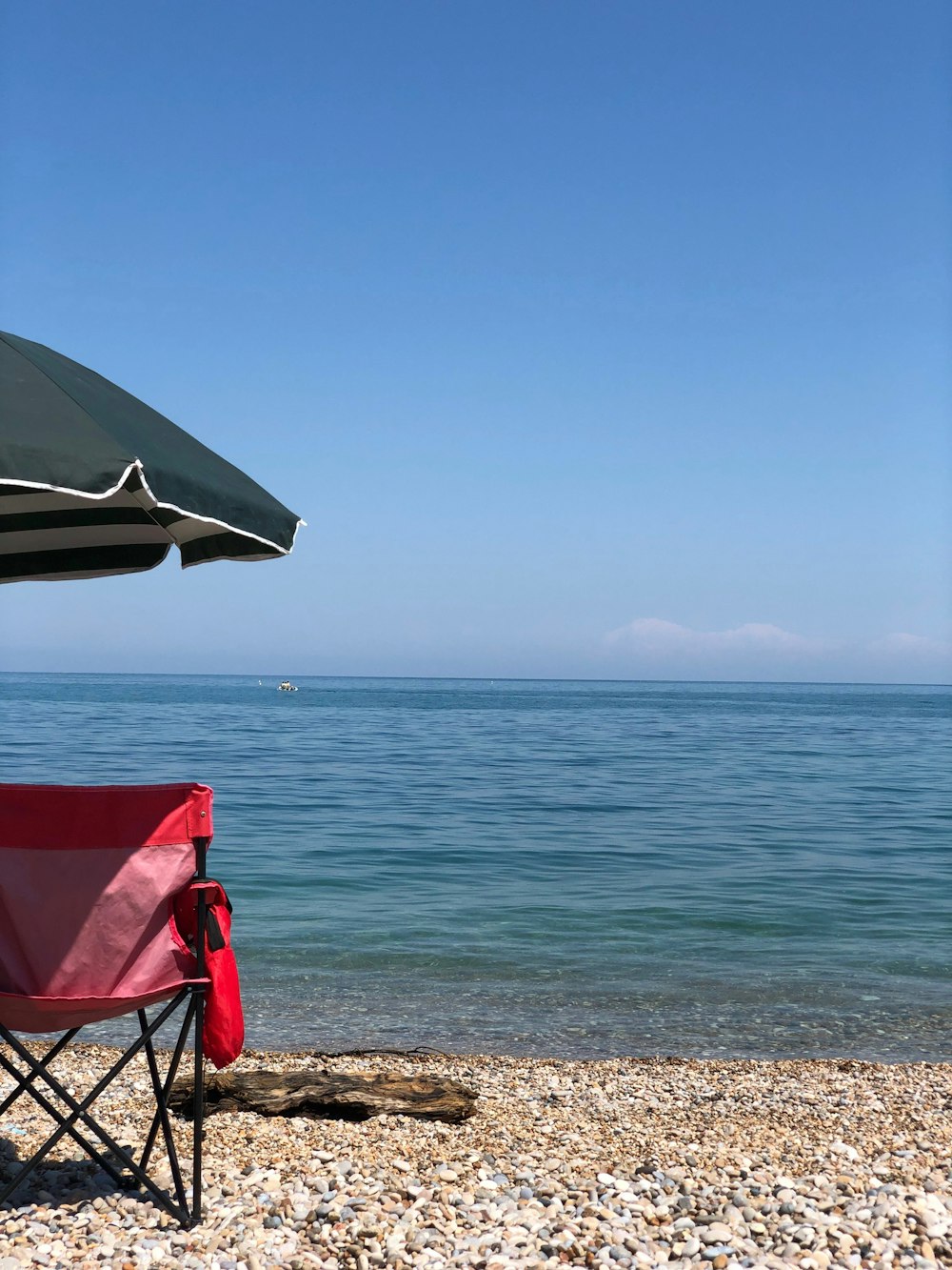 red and white folding chair on beach during daytime