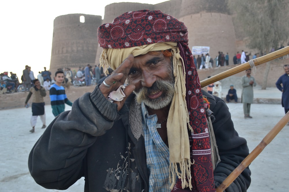 man in black jacket wearing red and yellow hat