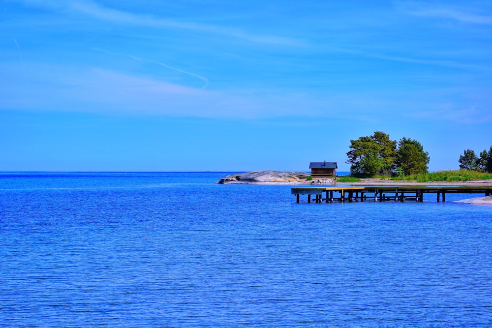 brown wooden dock on blue sea under blue sky during daytime