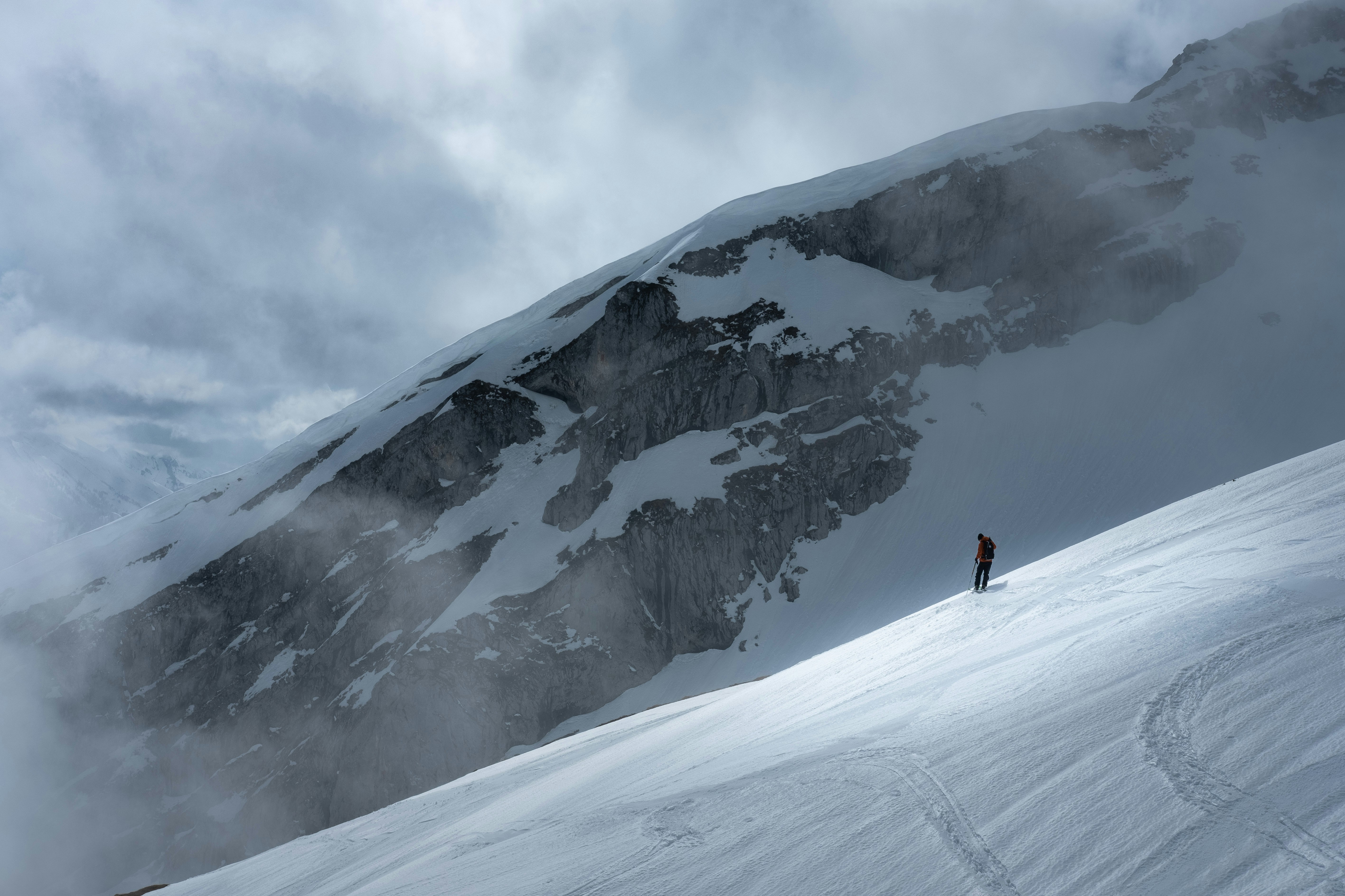 person in red jacket and black pants standing on snow covered mountain during daytime, Mountain spotlight