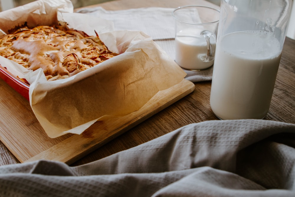 white ceramic mug beside brown bread on brown wooden tray