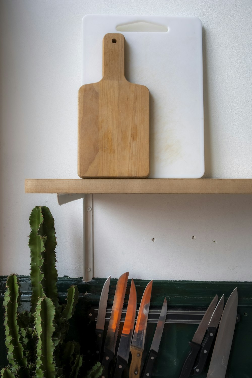 brown wooden chopping board on white wall