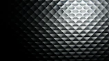 Close-up of a diamond-shaped light reflection on a dark, textured surface.