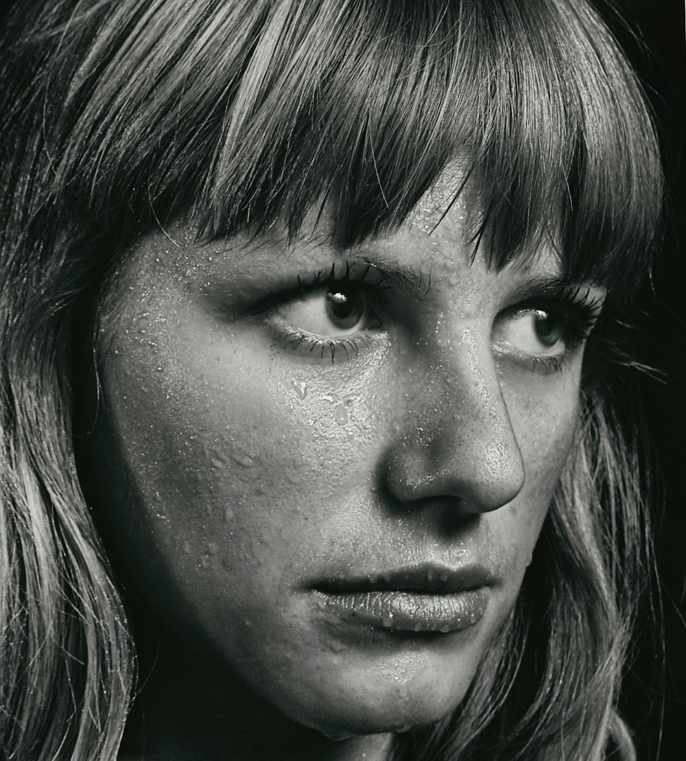 a black and white photo of a woman with freckles on her face