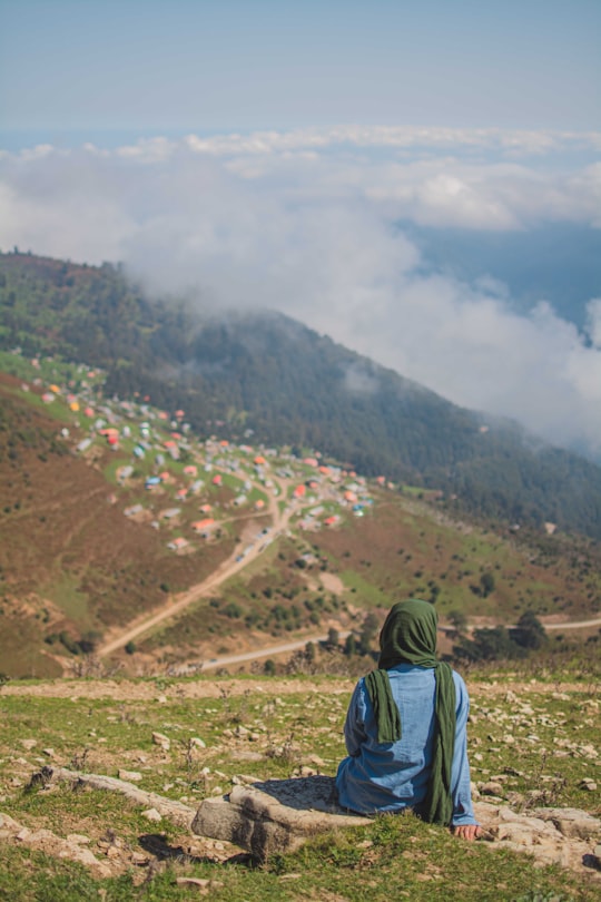 person in green and black hoodie standing on brown field during daytime in Gilan Province Iran