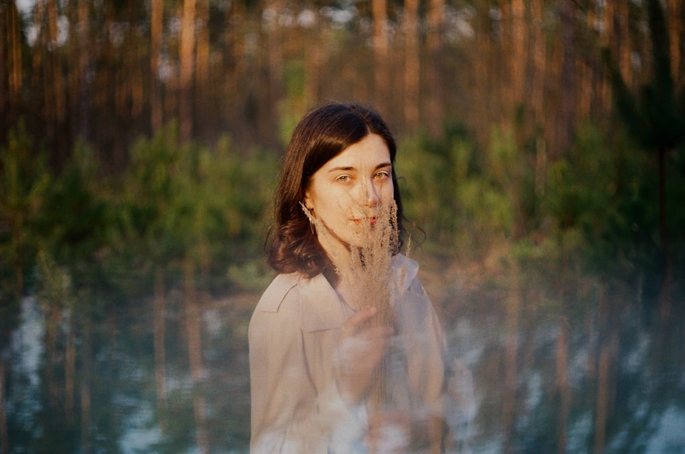 woman in white long sleeve shirt standing near body of water during daytime