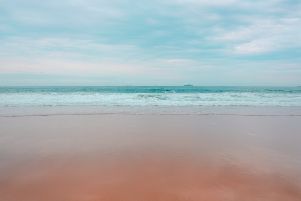 ocean waves crashing on shore during daytime